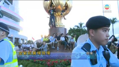 [現場]有示威者爬上金紫荊雕塑並掛上黑色橫額